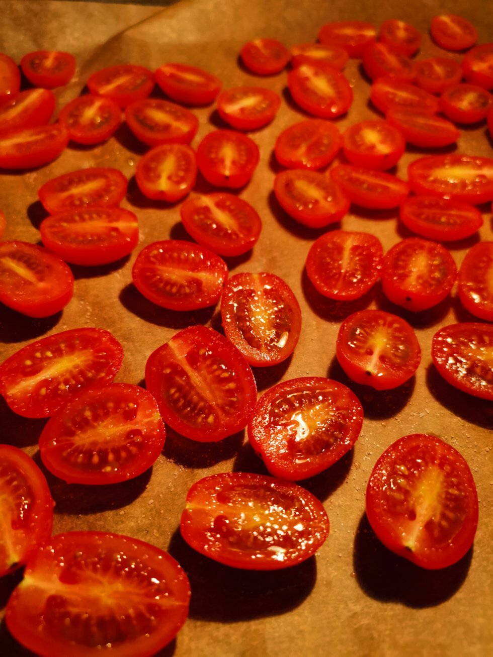 Halverede cherrytomater med olivenolie og salt på vej i ovnen.  - Semidried tomater i ovn