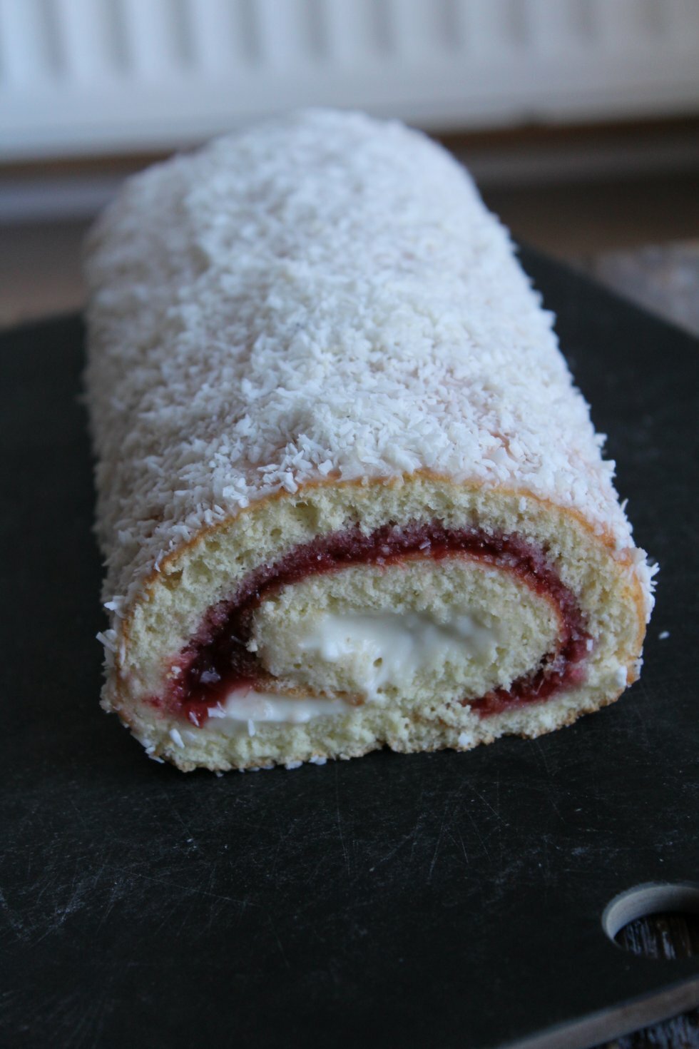 Færdig roulade 'overtrukket' med creme og kokosmel. - Roulade med rabarber og kokoscreme